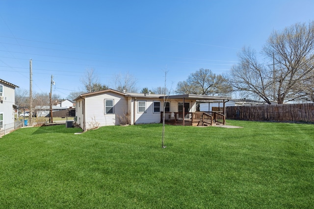 rear view of property with a fenced backyard, a lawn, central AC, and a wooden deck