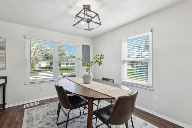 dining space featuring visible vents, a textured ceiling, baseboards, and wood finished floors