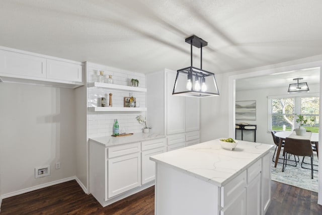 kitchen with light stone counters, white cabinets, dark wood-style floors, open shelves, and tasteful backsplash