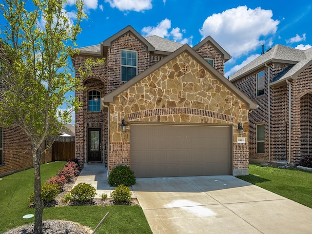 traditional home featuring a garage, brick siding, stone siding, driveway, and a front lawn