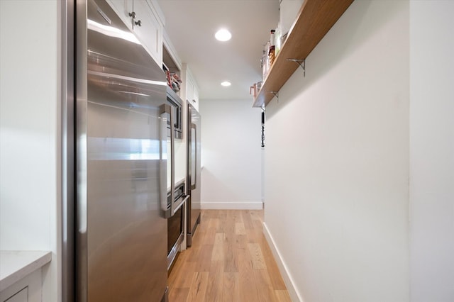 interior space with baseboards, light wood-type flooring, and recessed lighting