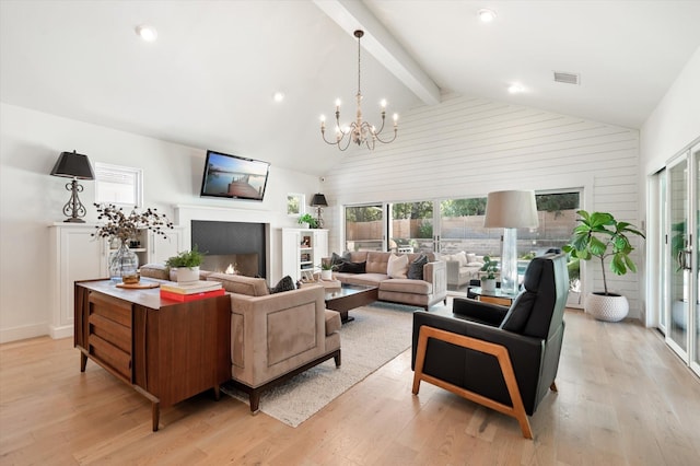 living area featuring light wood finished floors, visible vents, beamed ceiling, a fireplace, and a chandelier