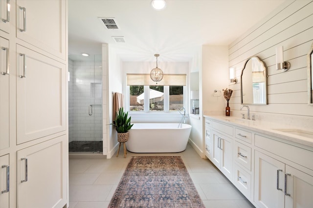 bathroom featuring visible vents, a soaking tub, tile patterned floors, a shower stall, and a sink