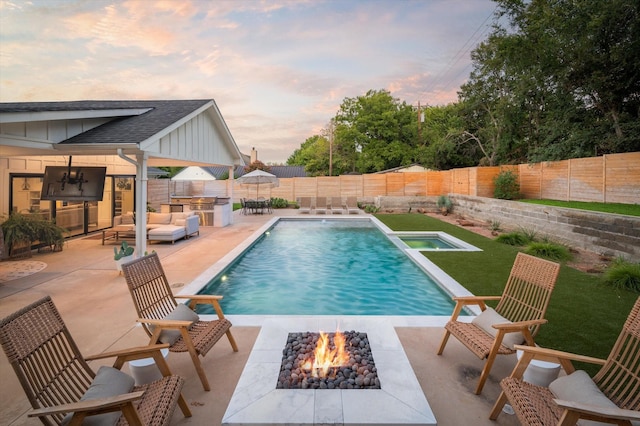 view of pool featuring a fenced backyard, a fire pit, a patio, and area for grilling