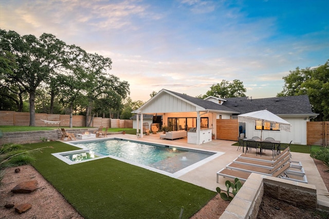 pool at dusk featuring a fenced in pool, area for grilling, a patio area, a fenced backyard, and an outdoor living space