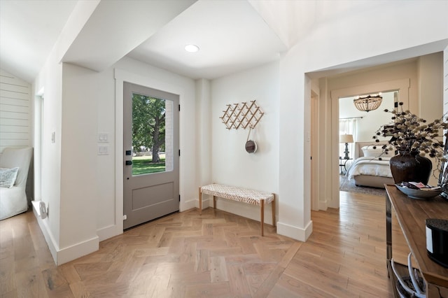 foyer entrance with recessed lighting, parquet flooring, and baseboards