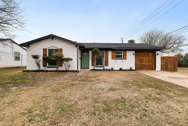 view of front of house with a garage, fence, a front lawn, and concrete driveway