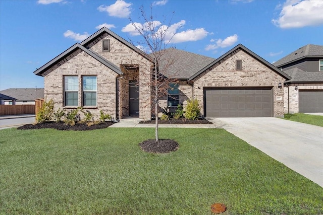 french provincial home featuring concrete driveway, brick siding, an attached garage, and a front lawn