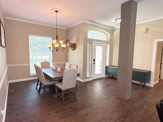 dining space with ornamental molding, dark wood finished floors, a notable chandelier, and decorative columns