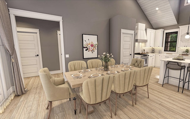 dining area with light wood-style flooring, recessed lighting, high vaulted ceiling, and baseboards