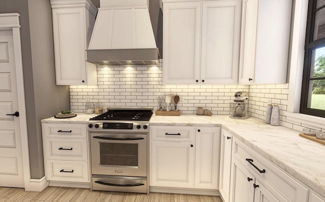 kitchen featuring white cabinets, custom exhaust hood, tasteful backsplash, and gas range