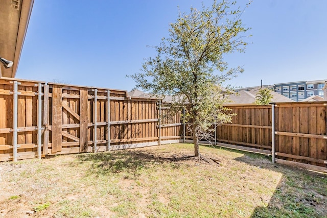 view of yard featuring a fenced backyard and a gate