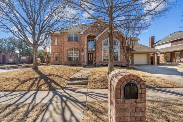 view of front of house featuring a garage, concrete driveway, and brick siding