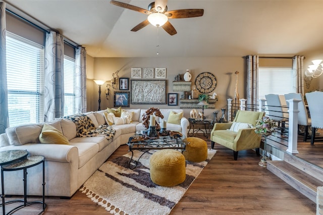 living area featuring vaulted ceiling, dark wood finished floors, and a ceiling fan