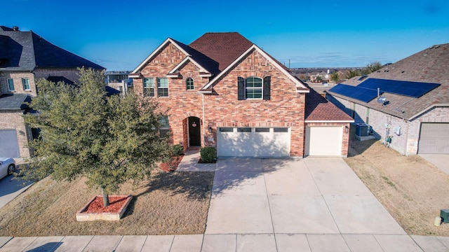 view of front of home featuring brick siding, driveway, and central AC