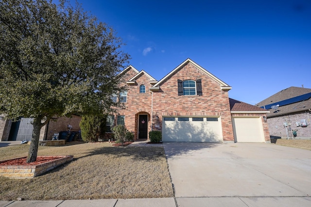 traditional-style home with a front yard, concrete driveway, brick siding, and an attached garage