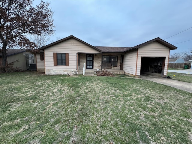 ranch-style home featuring covered porch, concrete driveway, an attached garage, and a front yard