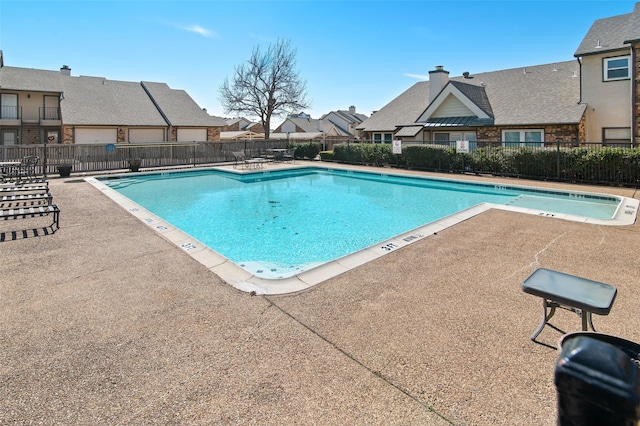 pool featuring a patio area, fence, and a residential view