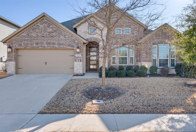 view of front of property with stone siding, brick siding, driveway, and an attached garage