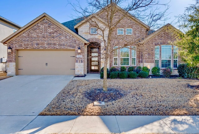 view of front facade with an attached garage, stone siding, concrete driveway, and brick siding