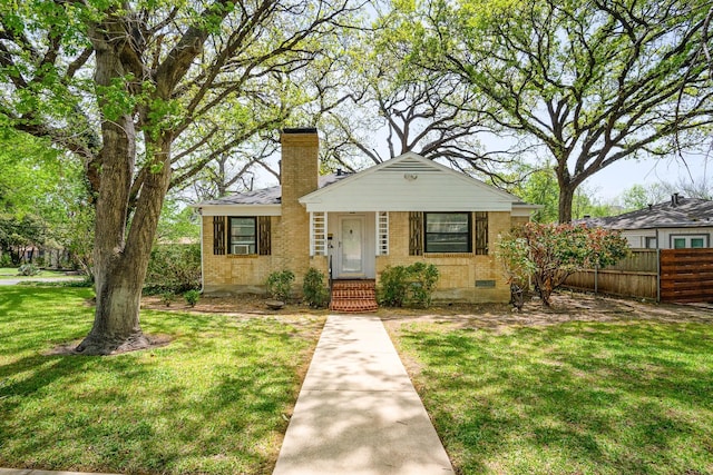 bungalow-style home featuring brick siding, crawl space, a front yard, and fence