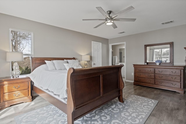 bedroom with ensuite bath, ceiling fan, visible vents, and dark wood finished floors