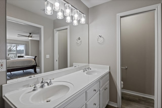 full bathroom featuring toilet, a sink, ensuite bath, and wood finished floors