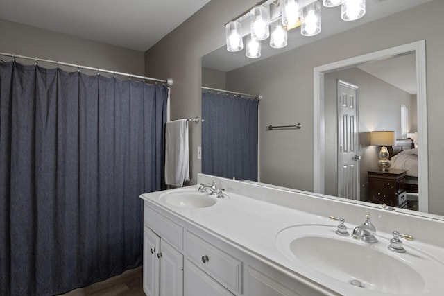 bathroom featuring double vanity, a sink, and connected bathroom