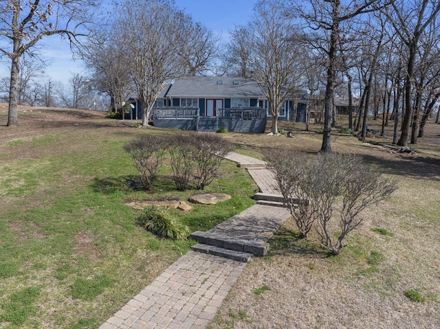 ranch-style house featuring a front lawn and a wooden deck