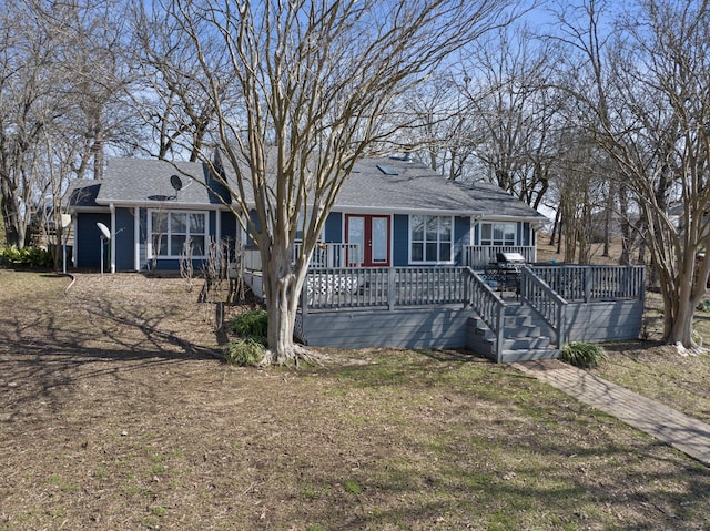 single story home with a deck and a shingled roof