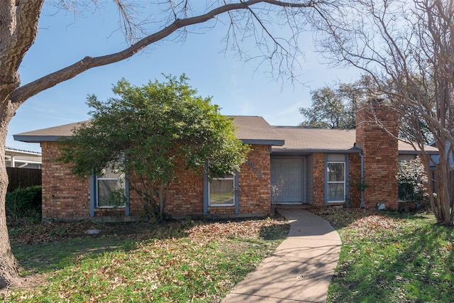 view of front of house featuring a front yard, a chimney, fence, and brick siding