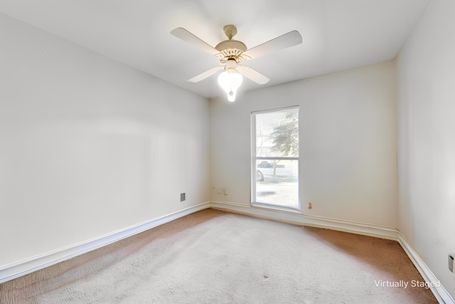 carpeted spare room with ceiling fan and baseboards