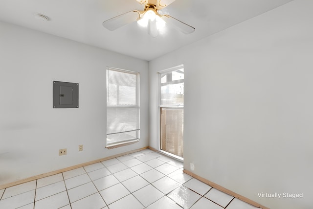 spare room featuring electric panel, ceiling fan, and baseboards