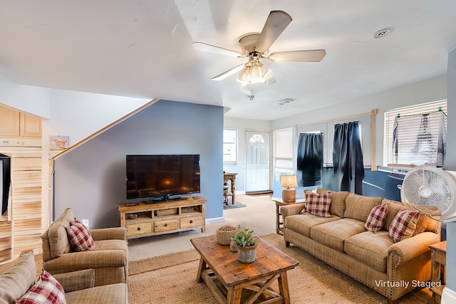 living room featuring baseboards, a healthy amount of sunlight, a ceiling fan, and light colored carpet