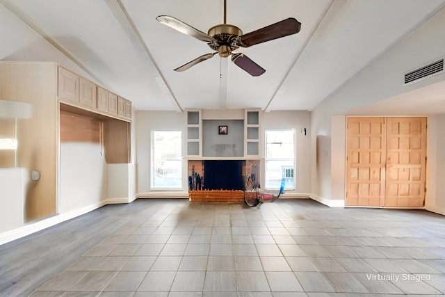 unfurnished living room with light tile patterned floors, baseboards, visible vents, beamed ceiling, and a brick fireplace