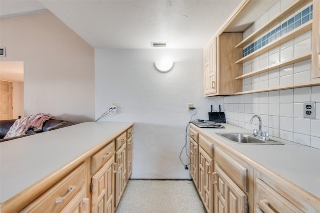 kitchen with open shelves, light countertops, backsplash, light brown cabinetry, and a sink