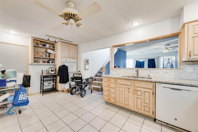 kitchen with decorative backsplash, light brown cabinetry, a sink, light stone countertops, and white appliances