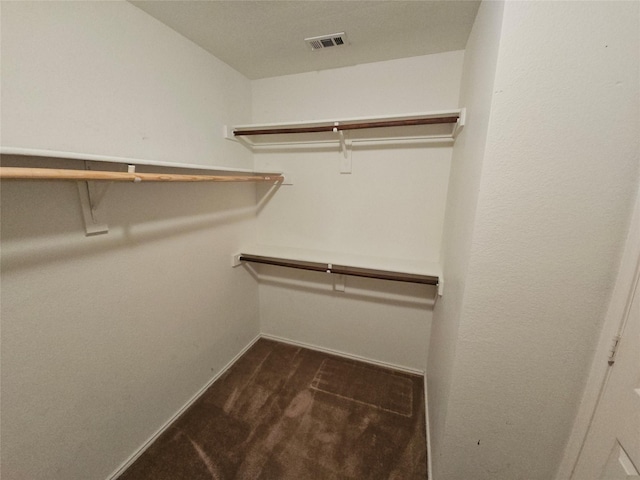 walk in closet with dark carpet and visible vents