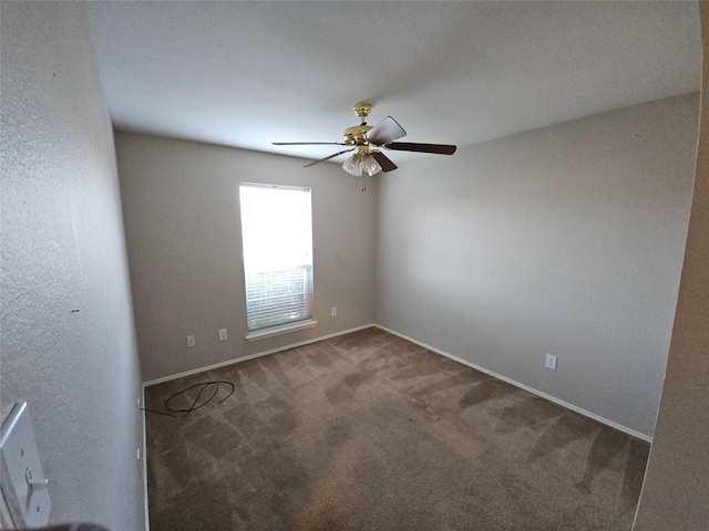 empty room featuring ceiling fan, carpet, and baseboards