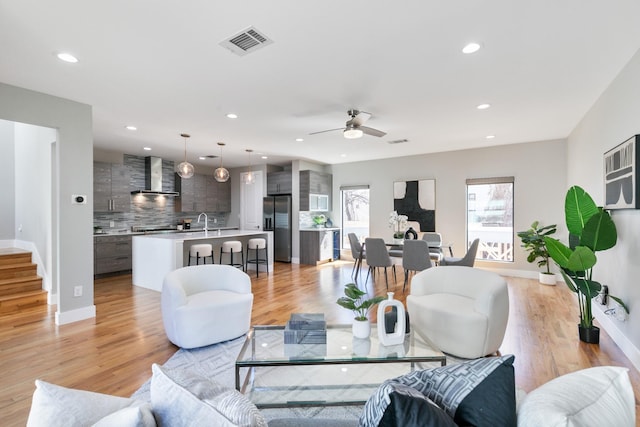 living area with light wood-style floors, recessed lighting, and visible vents