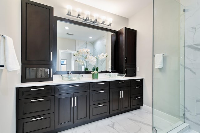 bathroom with marble finish floor, a marble finish shower, double vanity, visible vents, and a sink