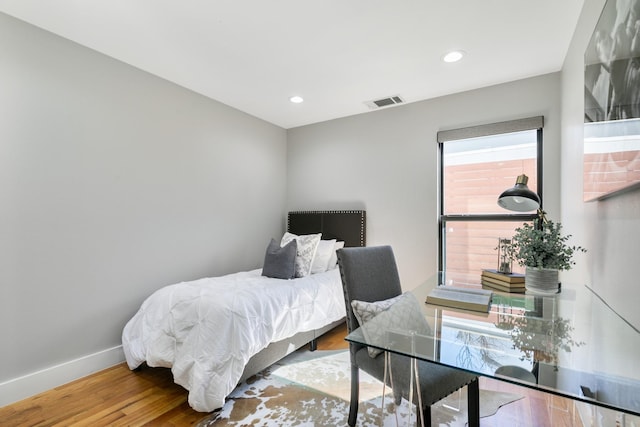 bedroom with visible vents, baseboards, wood finished floors, and recessed lighting