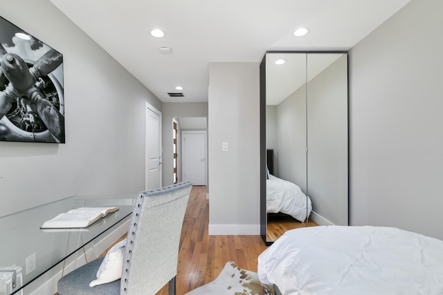 bedroom with recessed lighting, visible vents, baseboards, and wood finished floors