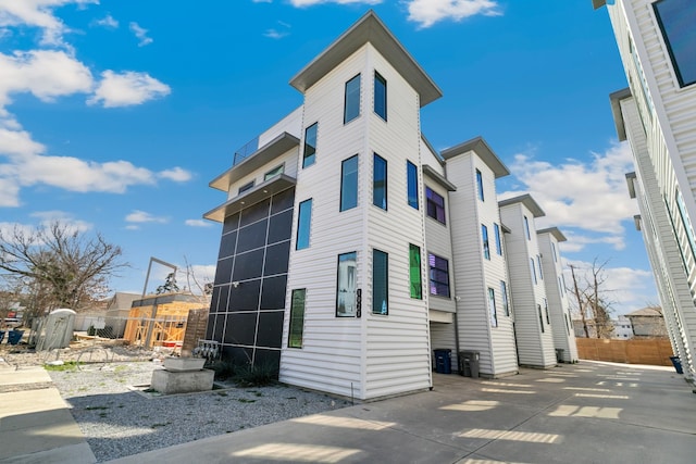 view of side of home with cooling unit and fence