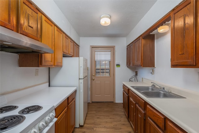 kitchen with under cabinet range hood, range with electric cooktop, light countertops, and brown cabinetry