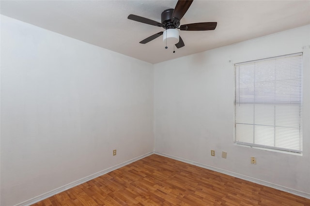 unfurnished room with ceiling fan, baseboards, and wood finished floors