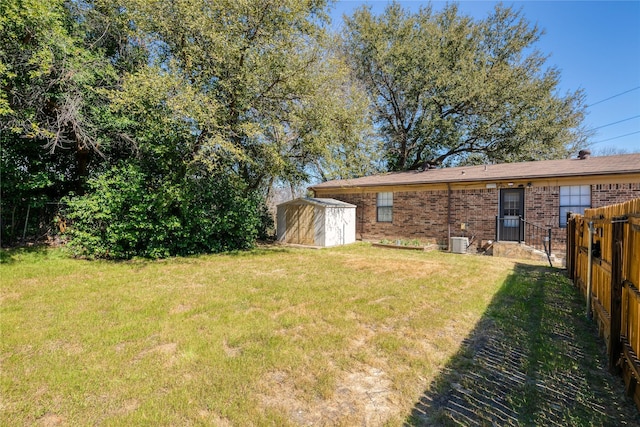 view of yard featuring cooling unit, fence, an outdoor structure, and a storage unit