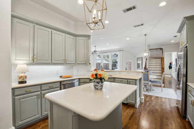 kitchen with gray cabinetry, light countertops, visible vents, and a center island