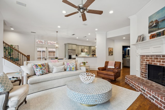 living area featuring ornamental molding, recessed lighting, a fireplace, and wood finished floors