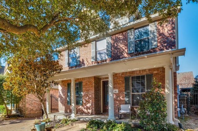 view of front of house featuring covered porch and brick siding